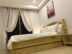 a bedroom with a wooden bed with a window at Umali Kayo at Megatower Residences II in Baguio
