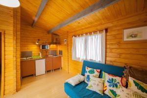 a living room with a blue couch in a cabin at Cabañas de la Romedina in Bañobárez
