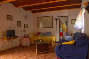 - un salon avec un lit et un canapé dans l'établissement La Rana Verde Casa Rural, à Los Romeros