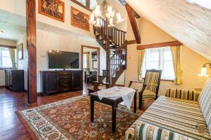 a living room with a staircase and a television at Hotel Stanica Kresowa Chreptiów in Lutowiska