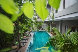 een zwembad in het midden van een gebouw met planten bij Sarina Boutique Hotel in Phnom Penh
