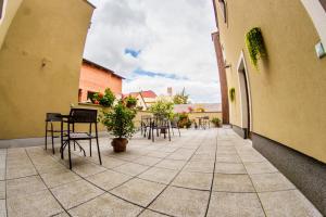 a patio with tables and chairs in a building at Penzion Černej pták in Jindřichŭv Hradec