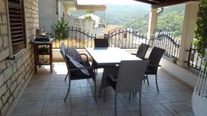 Una mesa y sillas en un balcón con vista. en apartman house Bjedov, en Povlja