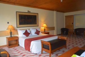 坎帕拉的住宿－高爾夫球場酒店，酒店客房带一张床、一张桌子和椅子