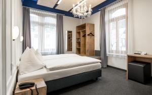 达沃斯Hotel Ochsen by Mountain Hotels的带床、书桌和窗户的卧室