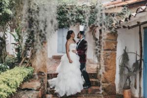 a bride and groom posing for a picture under an arch at Casa Raisol Barichara in Barichara