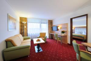 una camera d'albergo con divano e letto di Johannesbad Thermalhotel Ludwig Thoma a Bad Füssing
