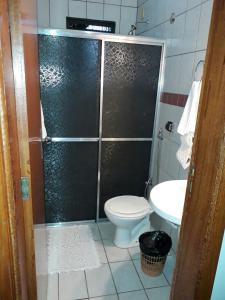 a bathroom with a shower with a toilet and a sink at Sevilha Park Hotel in Colorado