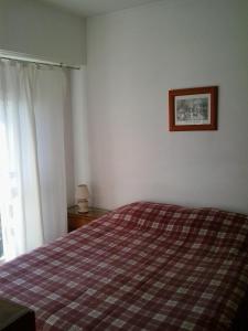 1 dormitorio con 1 cama y una foto en la pared en Panoramico Playa Grande -Solo Familias en Mar del Plata