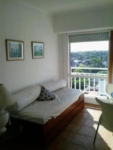 een bed in een kamer met een groot raam bij Panoramico Playa Grande -Solo Familias in Mar del Plata