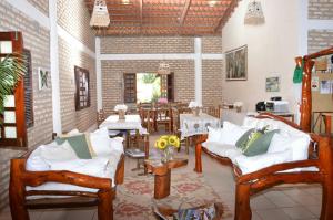 a living room with white couches and a dining room at Butterfly House in Flecheiras