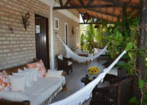 een veranda met een hangmat en een bank op een patio bij Butterfly House in Flecheiras