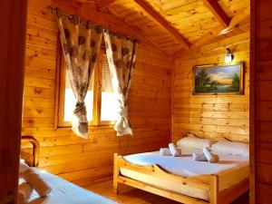 Cabaña de madera con 2 camas en una habitación en RAMIS Hotel & Outdoor Sports Center, en Përmet