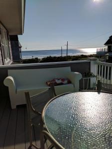 a table and chairs on a balcony with a view of the beach at Nantasket Beach - early birds - booking summer 2027 in Hull +8 photos