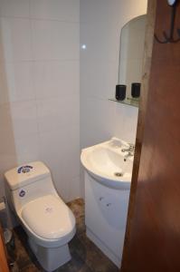 La salle de bains est pourvue de toilettes blanches et d'un lavabo. dans l'établissement Departamento Bahia Caldera, à Caldera
