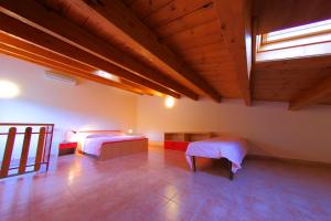 パッティにあるCasa Ale con giardino pensileのベッド2台が備わる木製の天井の客室です。