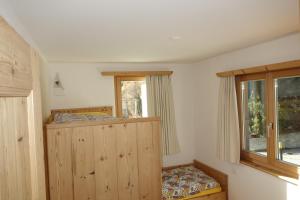 a bedroom with a wooden cabinet and a window at Chesa il Rifugio 1 in St. Moritz