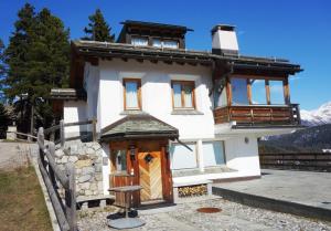 a house in the mountains with a wooden door at Chesa il Rifugio 1 in St. Moritz