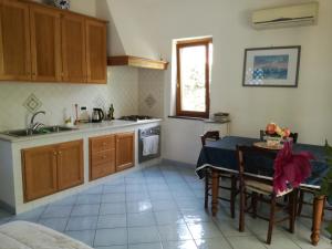 a kitchen with a table and a sink and a stove at Villetta Baia San Montano in Ischia