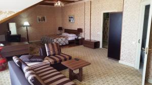 a living room with a couch and a bed at City Line Boutique Hotel in Tashkent