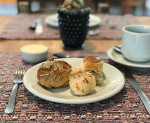 a plate of pastries on a table with a cup of coffee at Hotel Sion in Monte Sião
