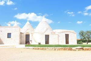 a large white building with three towers on top at I Trulli del Mulino in Locorotondo