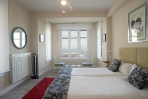 1 dormitorio con cama grande y ventana grande en San Diego - Iberorent Apartments, en San Sebastián