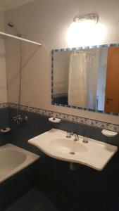 La salle de bains est pourvue d'un lavabo, d'un miroir et d'une baignoire. dans l'établissement Hosteria Tres Picos, à Lago Puelo