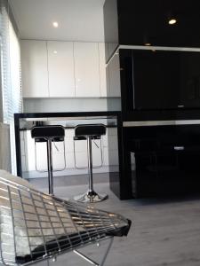 kuchnia z 2 stołkami barowymi i telewizorem w obiekcie Apartament na Złotej w Kielcach