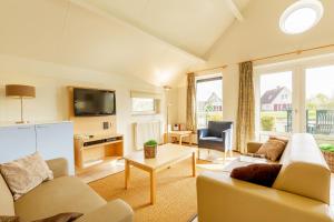 a living room with a couch and a tv at Center Parcs Sandur Emmen in Emmen