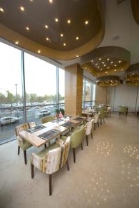 a dining room with tables and chairs and windows at Best Western Plus Pearl Creek in Dubai