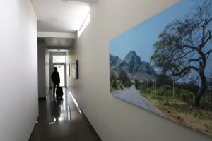 Un uomo in piedi in un corridoio che guarda una finestra di Casa Andina Standard Piura a Piura