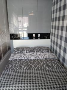 a bedroom with a bed with a checkeredkered bedspread at Apartament na Złotej in Kielce