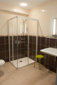 La salle de bains est pourvue d'une douche, d'un tabouret jaune et d'un lavabo. dans l'établissement Le Jardin de la Reyssouze, à Gorrevod