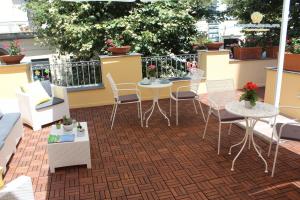 um pátio com mesas e cadeiras numa varanda em Residenza Scarlatti em Nápoles