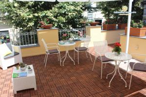 een patio met tafels en stoelen op een balkon bij Residenza Scarlatti in Napels