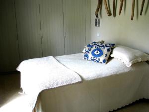 ein weißes Bett mit blauen und weißen Kissen darauf in der Unterkunft Maison RR in Saint-Tropez