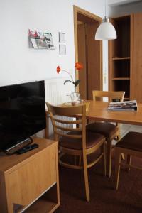 uma sala de jantar com uma mesa e uma televisão em Hotel Dat greune Eck em Soltau