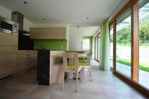 a kitchen with green walls and a table and chairs at Panoramahof in Kastelbell-Tschars