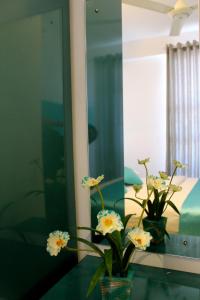 un jarrón con flores en una mesa frente a un espejo en Mount Princess, en Mount Lavinia