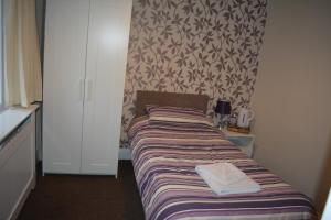 
a bedroom with a bed and a desk at The Sefton Hotel in Bridlington
