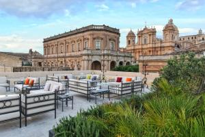 a building with tables and chairs in front of it at Gagliardi Boutique Hotel in Noto
