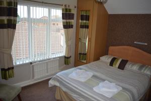 a bedroom with a bed and a window at The Sefton Hotel in Bridlington