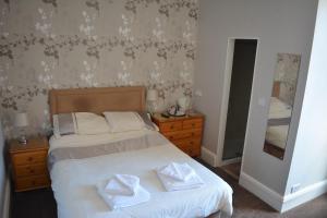 
a bedroom with a bed and a dresser at The Sefton Hotel in Bridlington
