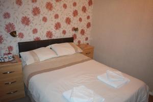 a bed with a white comforter and pillows at The Sefton Hotel in Bridlington
