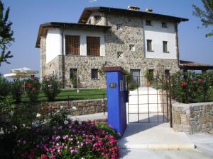 dom z niebieskimi drzwiami przed dziedzińcem w obiekcie Massoni Bed and Breakfast w mieście Peschiera del Garda