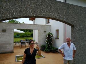 a man and a woman standing outside of a house at Aganis in Casarsa della Delizia