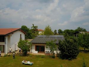 a person laying on a lawn in front of a house at Aganis in Casarsa della Delizia