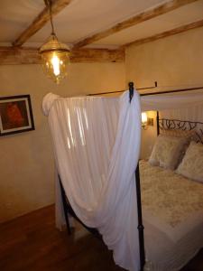 a bedroom with a bed with a canopy at Mas du Puits d'Amour in Orange