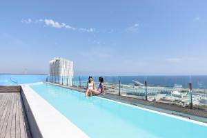 two people are lounging on a balcony overlooking the ocean at Barcelona Princess in Barcelona